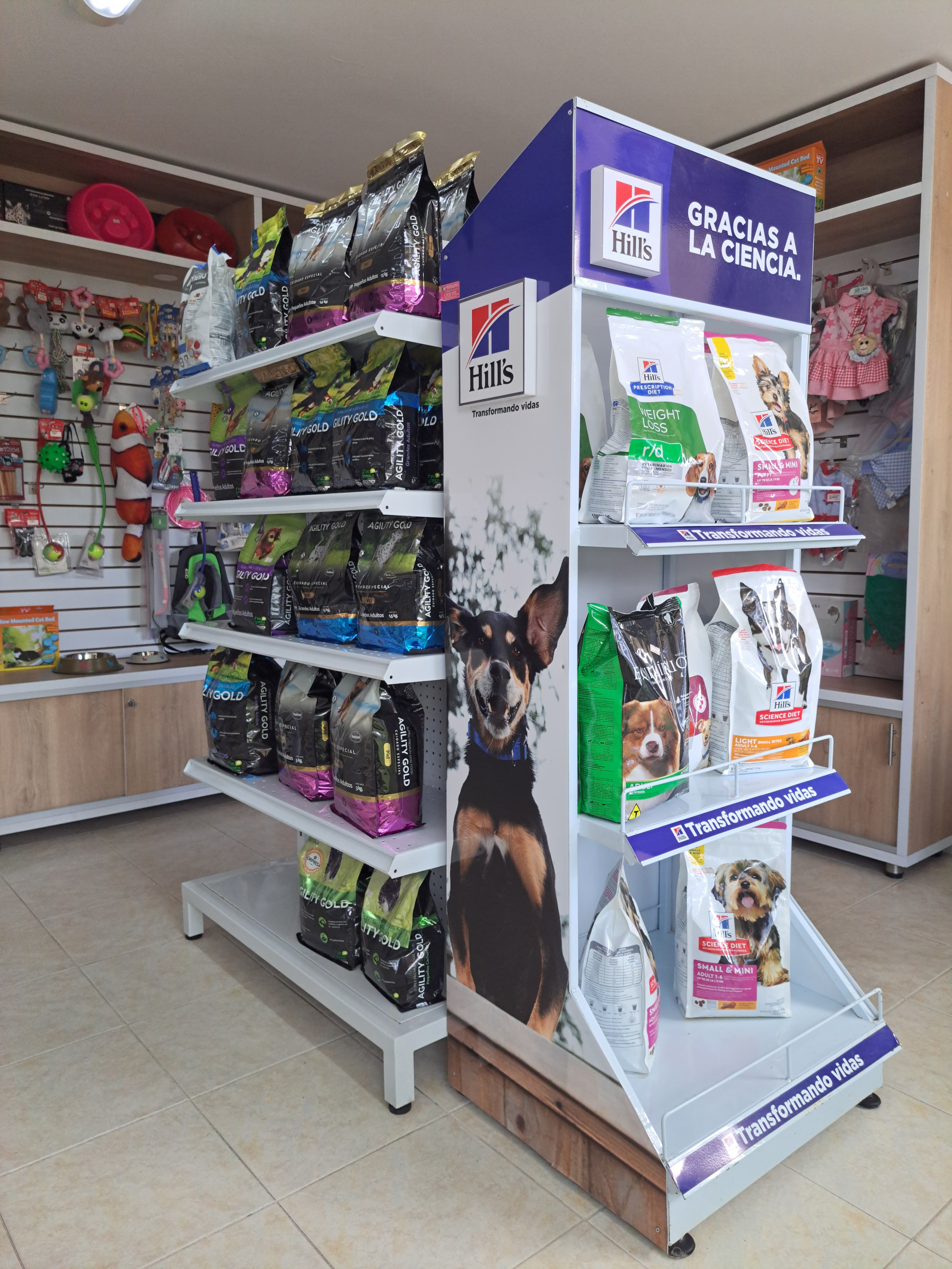 Retail display stand featuring Hill's and Agility Gold dog food bags and a dog graphic.